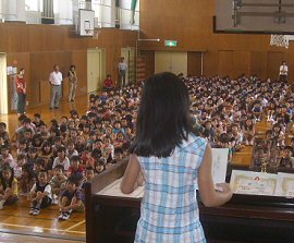 a third grader presents her reflection on the last semester to the weekly assembly