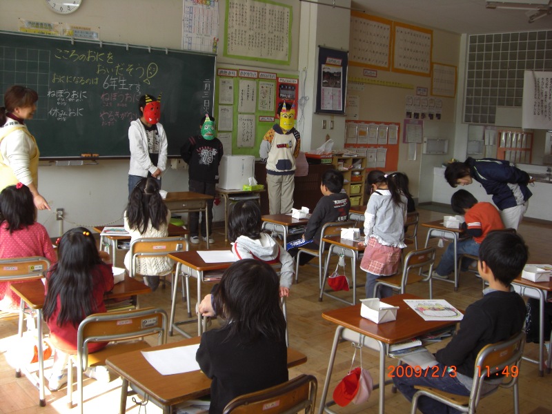 sixth graders visit a first grade class to show off the masks they made for Setsubun